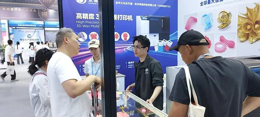 Des visiteurs discutent de l'équipement d'impression 3D en cire avec l'équipe Cprint 3D à l'exposition de Yiwu