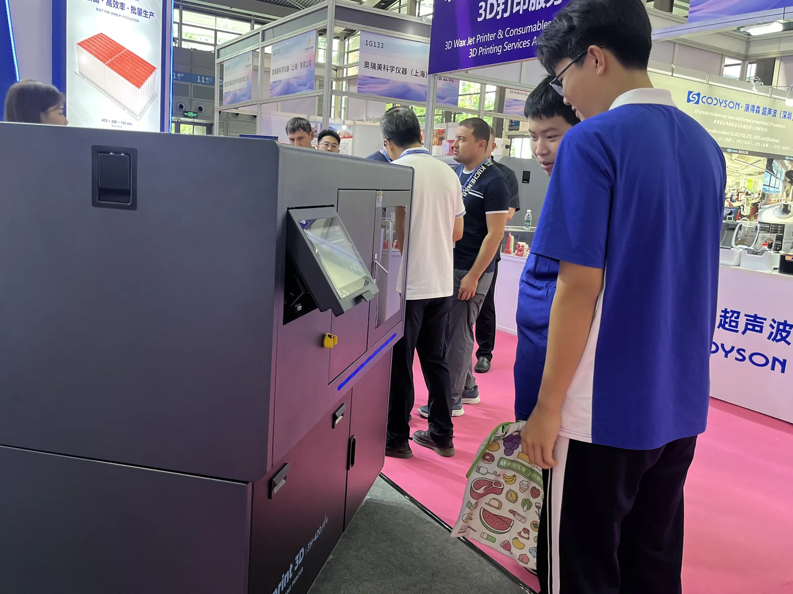 Zwei Schüler betrachten den 3H-420 Plus am Stand von Cprint 3D aus der Nähe