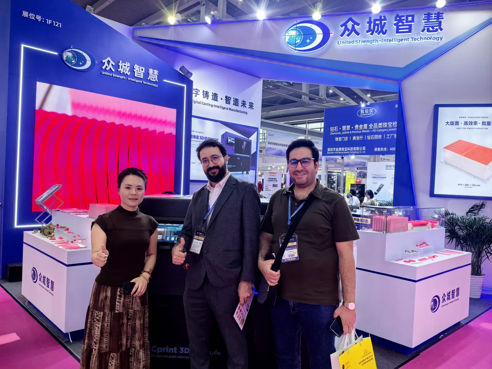 Mitarbeiter von Cprint 3D mit zwei internationalen Besuchern am Messestand