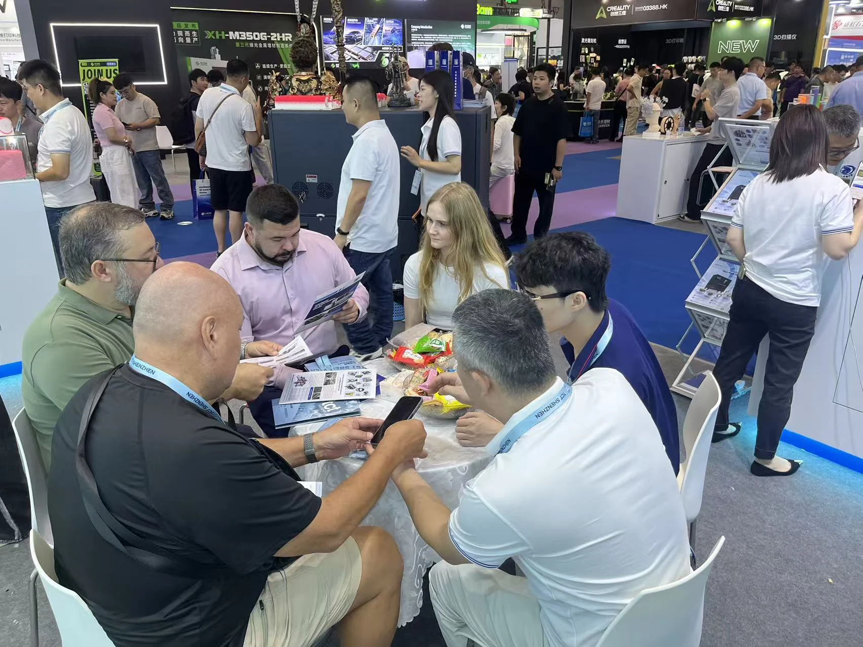A equipe da Cprint3D sentada com clientes que consultam os materiais de produto