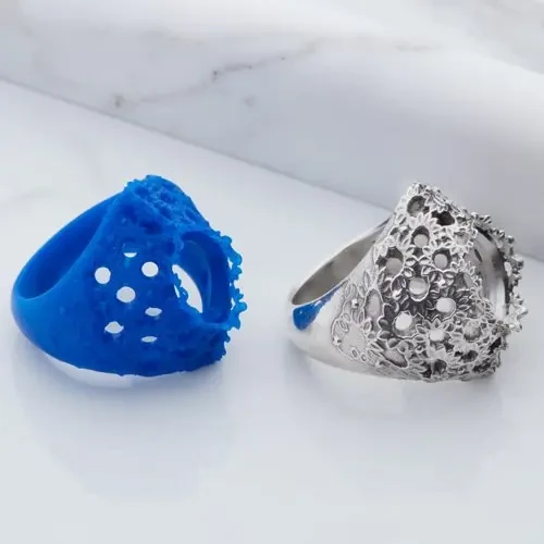 Blue openwork ring model beside a silver-colored ornamental ring